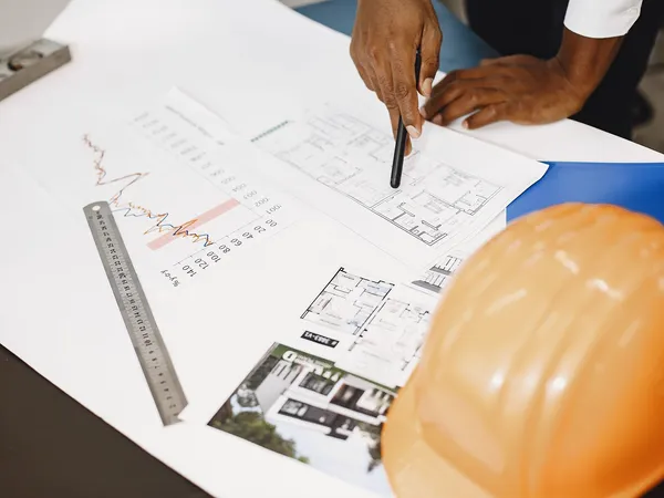 Análise de planta e documentação técnica sobre mesa de trabalho · AM&D Engenharia